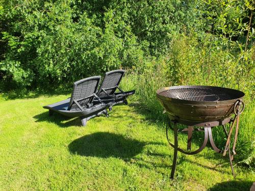 two chairs and a grill in the grass at Puddleduck Valley in Holsworthy