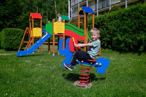 a young boy is playing on a playground at Mercure Karpacz Skalny in Karpacz