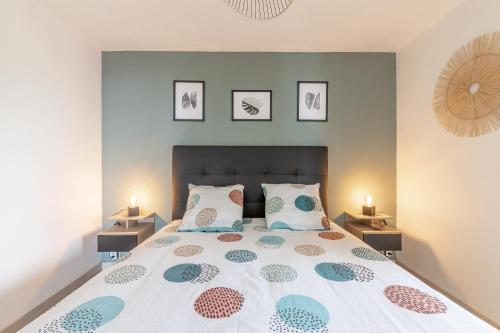 een slaapkamer met een groot bed met drie foto's aan de muur bij Au port de Binic - Loggia Vue mer - 50m de la plage in Binic