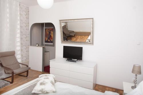 a living room with a tv and a mirror at Old Town Studio by MRG Apartments in Bucharest