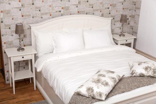 1 dormitorio con 1 cama blanca y 2 mesitas de noche en Old Town Studio by MRG Apartments, en Bucarest