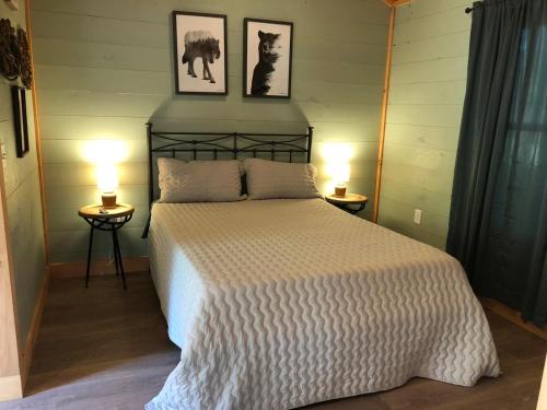 a bedroom with a large bed with two lamps at Avenwood Cabins in Logan