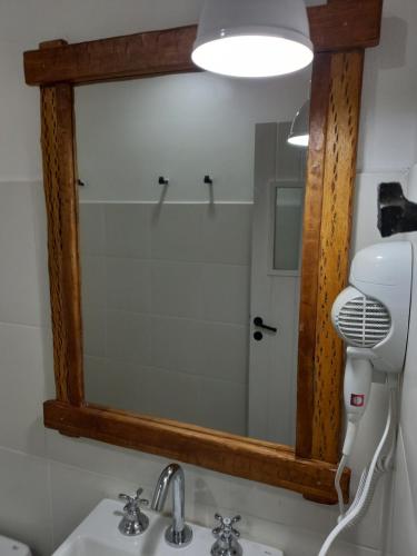 a mirror above a bathroom sink with a hair dryer at Kay Pacha in Tilcara