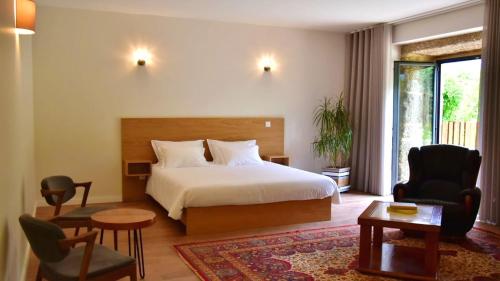 um quarto com uma cama, uma cadeira e uma mesa em 7 bedrooms mansion with enclosed garden and wifi at Valdreu 