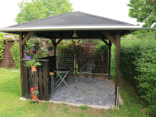 a wooden gazebo with a table and chairs at Ferienwohnung Nordstadt in Forst