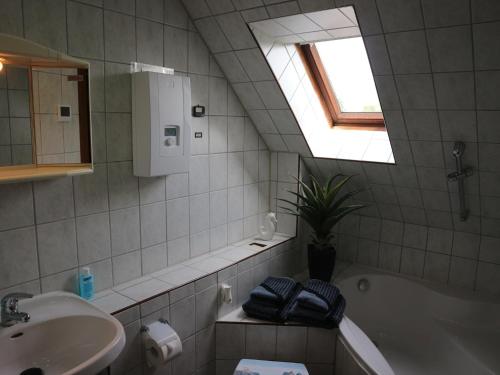 a bathroom with a sink and a tub and a window at Ferienwohnung Nordstadt in Forst