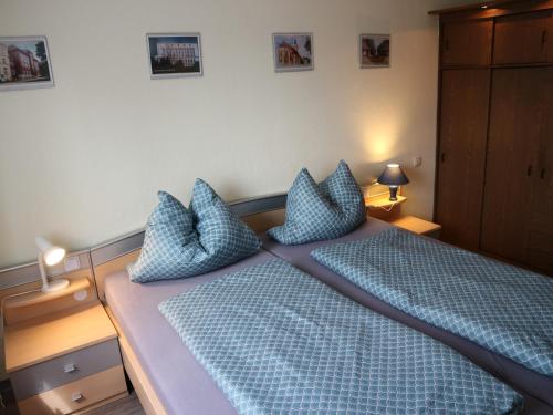 a bedroom with a bed with blue sheets and pillows at Ferienwohnung Nordstadt in Forst