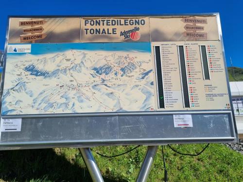 a sign for a ski resort with a snow covered mountain at BMP APARTMENT EDELWEISS PASSO DEL TONALE in Passo del Tonale