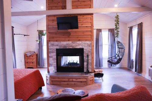 ein Wohnzimmer mit einem Kamin und einem Flachbild-TV in der Unterkunft Avenwood Cabins in Logan