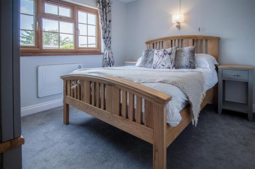 a bedroom with a wooden bed and a window at Lilac Cottage - 1 Bedroom Cottage - Amroth in Amroth