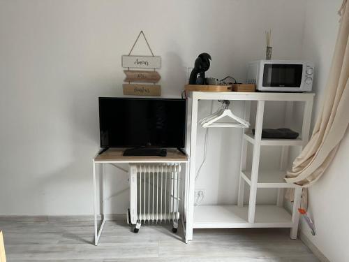 a white stand with a television on it in a room at Chambre double indépendante BALI au sein du domaine PASSELOUP in Liergues