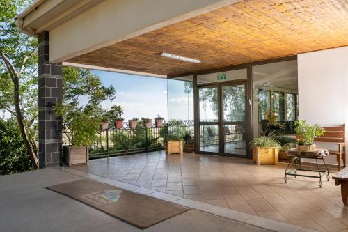 an outdoor patio with glass doors and a balcony at Keshet Yehonatan Country Lodging in Keshet