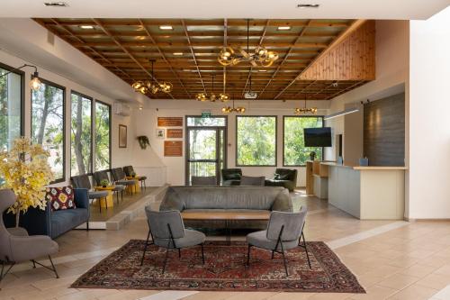 a lobby with a couch and a table and chairs at Keshet Yehonatan Country Lodging in Keshet