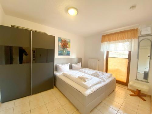 ein Schlafzimmer mit großem Bett und Fenster in der Unterkunft Ferienwohnungen Stadtmitte - Fewo 1 in Sassnitz