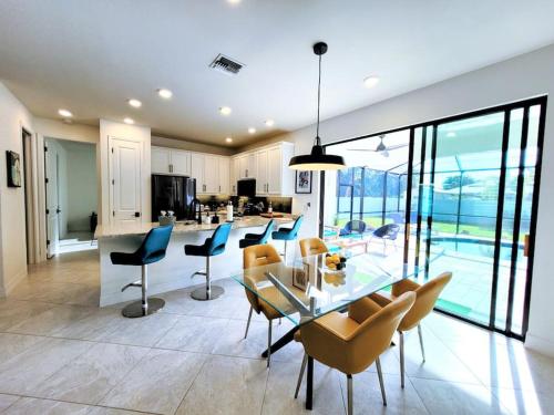 eine Küche und ein Esszimmer mit einem Glastisch und Stühlen in der Unterkunft Blue Door Retreat - Luxury Pool Home - sleeps 8 in Cape Coral