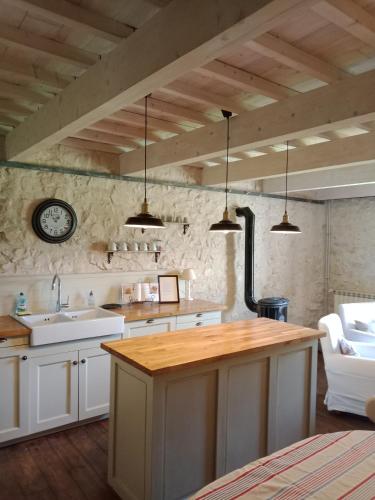 une cuisine avec des armoires blanches et un comptoir en bois dans l'établissement mas de karlotte, à Pernes-les-Fontaines