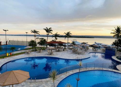 a hotel with two pools and a view of the water at Flat Lake Side cantinho café Lago Paranoá Brasília Df in Brasília