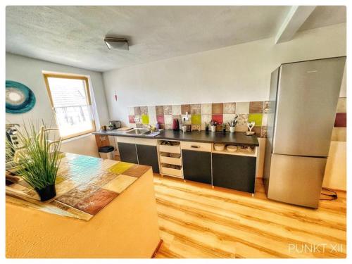 een keuken met een roestvrijstalen koelkast en een tafel bij Wohnung 4 in Burghaslach