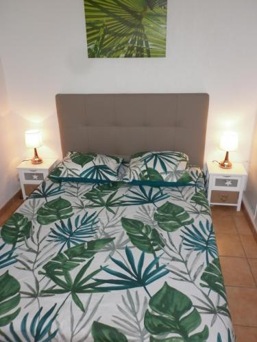 - une chambre avec un lit et une couette verte et blanche dans l'établissement Villa Samaria 3 Pièces Mezzanine CAP D'AGDE, au Cap d'Agde