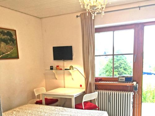 - une chambre avec un lit, un bureau et une fenêtre dans l'établissement Ferienwohnung Spitzstein Bentz, à Sachrang