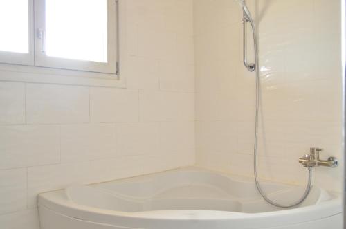 a white bathroom with a shower and a tub at Ranch Tanit Djerba in Midoun