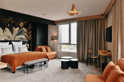ein Schlafzimmer mit einem Bett und ein Wohnzimmer in der Unterkunft Golden Tulip Reims in Bezannes-les-Reims