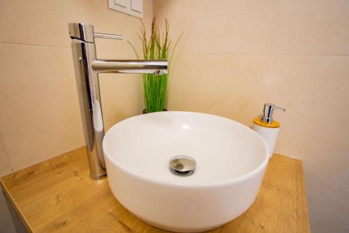 a white sink in a bathroom with a plant at Sky Penthouse Old Bridge with sauna and jacuzzi in Mostar