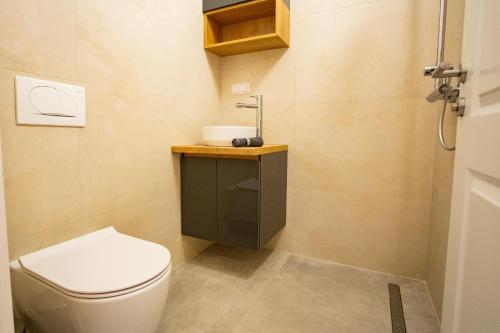 a small bathroom with a toilet and a sink at Sky Penthouse Old Bridge with sauna and jacuzzi in Mostar