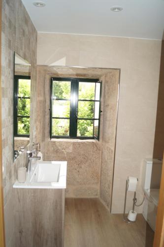 La salle de bains est pourvue d'un lavabo, d'une fenêtre et de toilettes. dans l'établissement Casa Marisa, à Teo