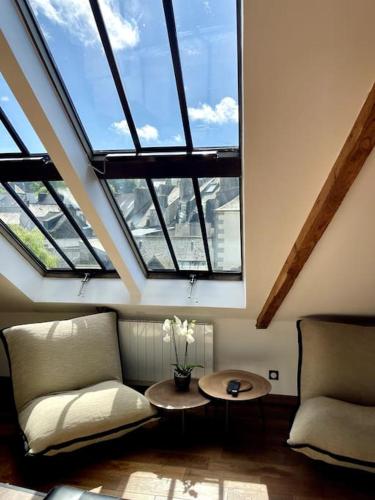 a room with a couch and a table and windows at Loft à Pont-Aven, Vue panoramique sur l'Aven in Pont-Aven