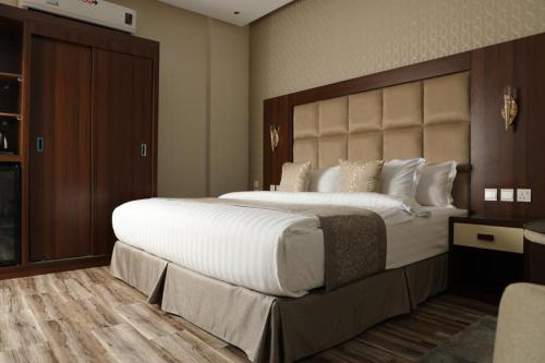 a bedroom with a large bed with a large headboard at فندق روند in Hafr Al Baten