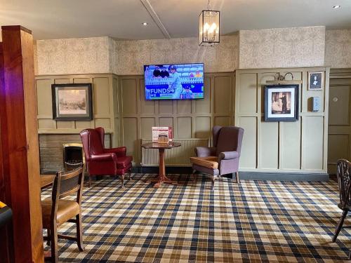 a waiting room with chairs and a tv on the wall at Vale of York in Thirsk