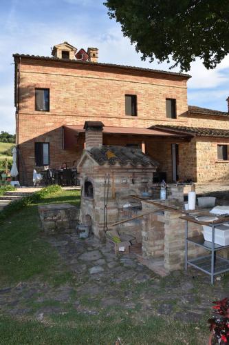 a brick building with a stone oven in front of it at Collerovere Country House in SantʼAngelo in Pontano