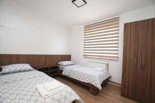 a bedroom with two beds and a window at Zanes Apartment in Kladovo