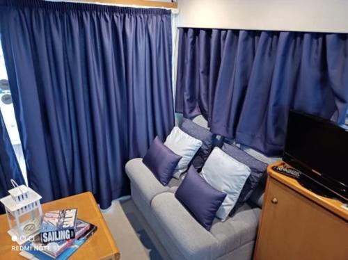 a living room with a couch with purple pillows at Barco Apartamento Buzios III Cascais in Cascais