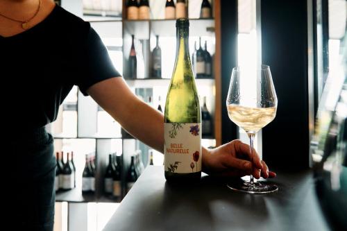 a person holding a wine bottle and a glass at ARX Guesthouse in Schladming
