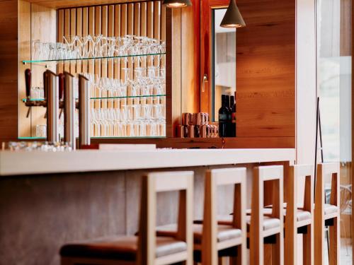 a bar with chairs and glasses on the wall at ARX Guesthouse in Schladming