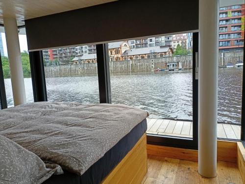 a bedroom with a large window with a view of the water at Hauseboat Prague in Prague