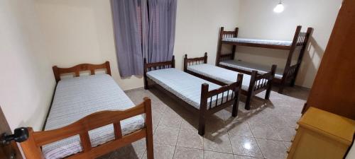 una habitación con tres camas en una habitación en Sitio em Atibaia - Sitio Beija-Flor, en Atibaia