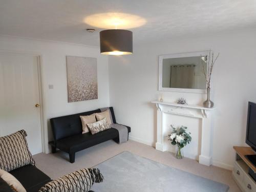 a living room with a couch and a television at Stamford Redcot Gardens Stylish 2 bed Family town house with parking in Lincolnshire