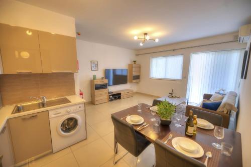 a kitchen and living room with a table and a sink at Centrally located and tastefully furnished one bedroom apartment CKNI1-1 in Il-Gżira