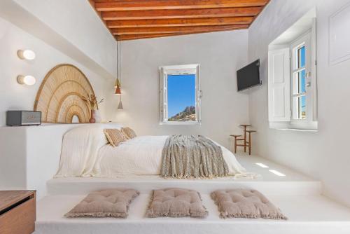 een slaapkamer met een groot bed met 2 tapijten bij Peni sol Superior Studios Lindos in Lindos