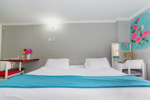 a bedroom with a bed and a table and chairs at ApartaSuites & Hotel Bogota Suamox in Bogotá