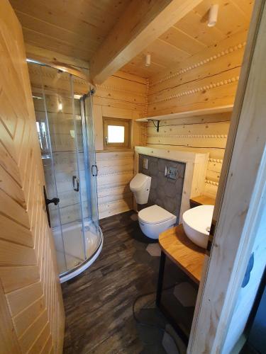 a wooden bathroom with two toilets and a shower at Dom pod Baranią - Wisła - sauna, jacuzzi, tężnia & widok na góry in Wisła