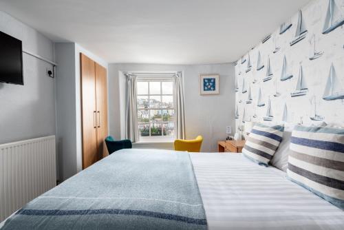 um quarto com uma cama grande e uma janela em Harbour View em Brixham