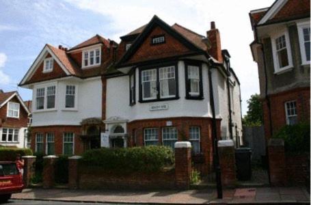 uma grande casa branca e vermelha numa rua em Beachy Rise em Eastbourne