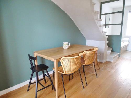 une table de salle à manger avec des chaises et un vase dessus dans l'établissement Iris Bel appartement à 100m du Port, à Saint-Martin-de-Ré