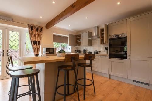 a kitchen with white cabinets and bar stools at Bridge Hotel Brandon in Brandon