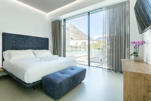 a bedroom with a bed and a large window at DOMUS CAVOUR Rooms&Suites in Tirano