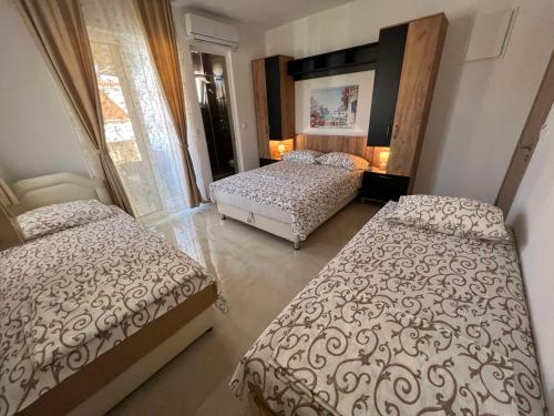 a bedroom with two beds and a window at Apartments Pericic in Sutomore